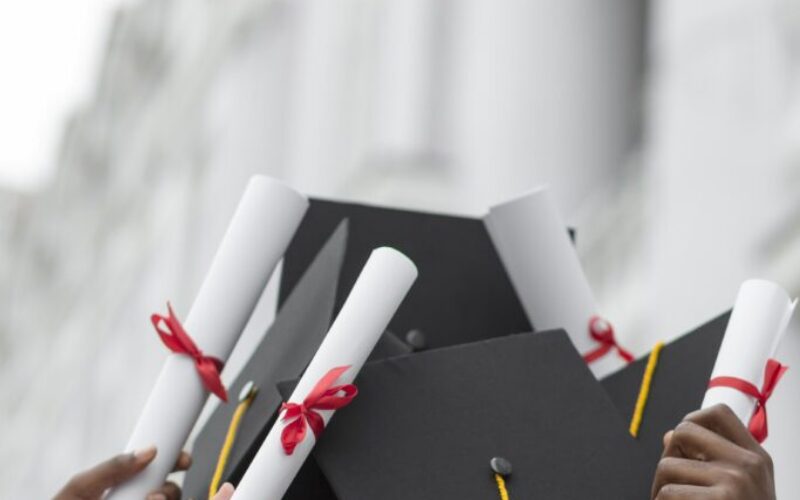 close-up-hands-holding-diplomas-caps